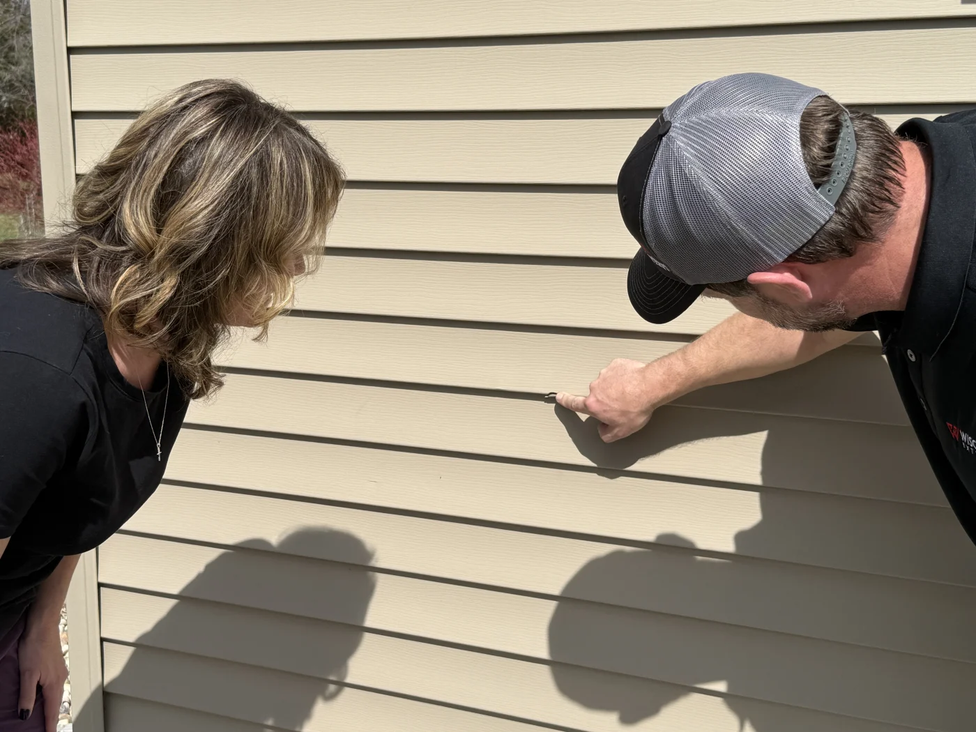 FAQs | Kaukauna | Wisconsin Exteriors The owner of Wisconsin Exteriors is educating a homeowner on the proper materials to use for a home upgrade