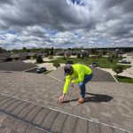 Owner of Wisconsin Exteriors on top of home inspecting its roof