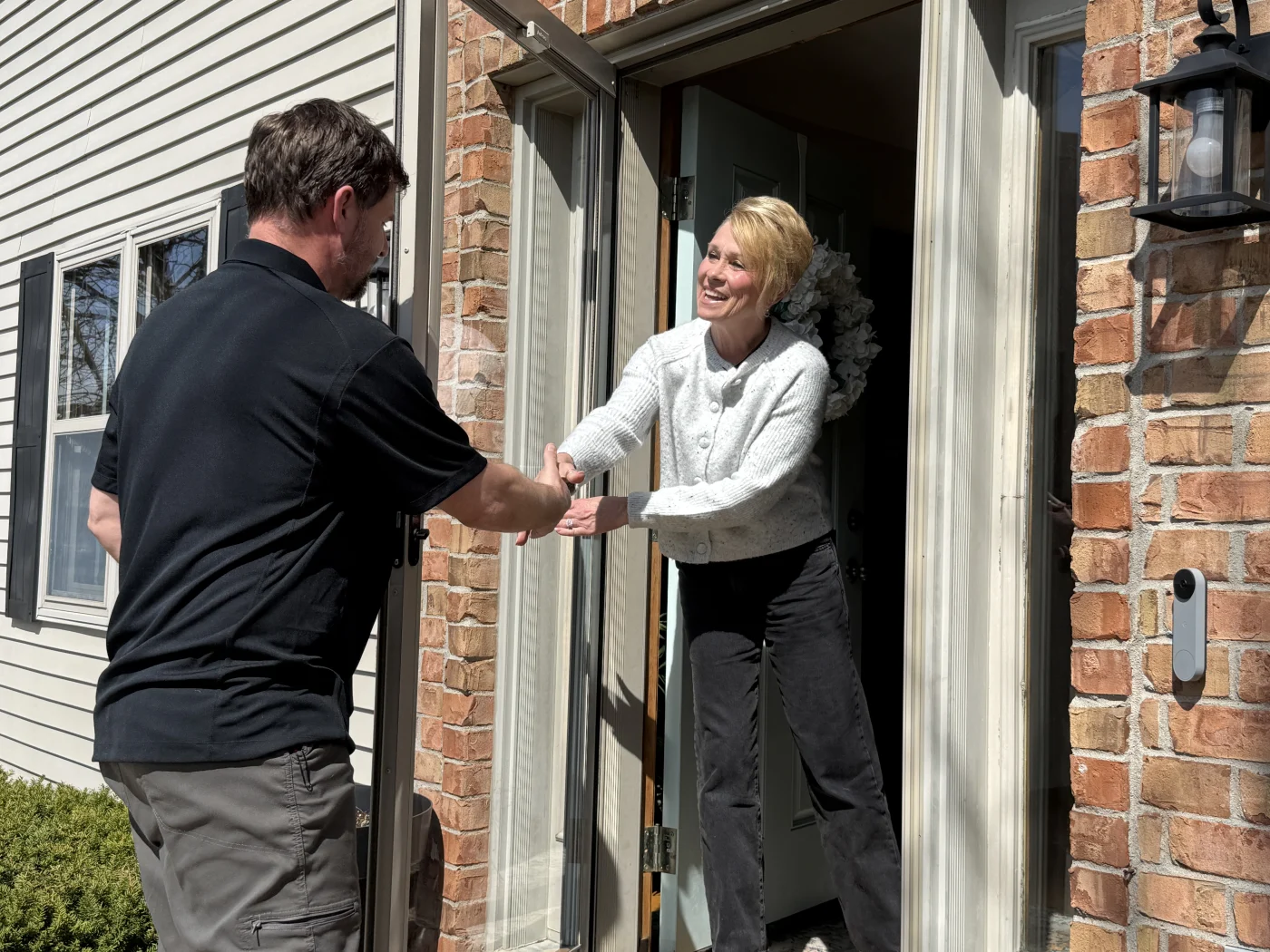 Top-Rated Roof Replacement Warranty | Kaukauna | Wisconsin Exteriors Owner of Wisconsin Exteriors shaking hands with Kaukauna homeowner