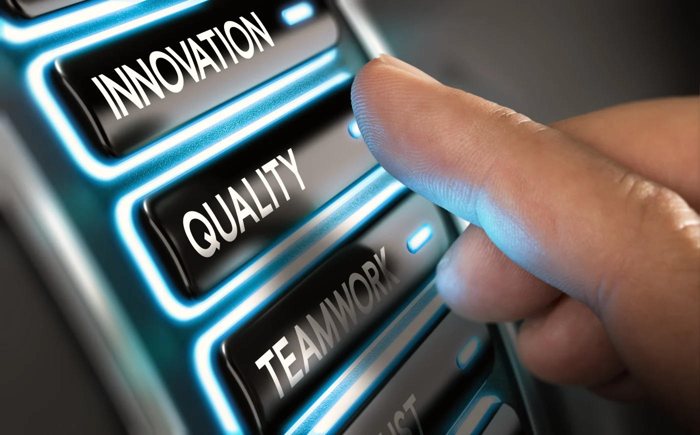 Company Values, Innovation, Quality And Teamwork A finger about to press a button that says Quality, which has an Innovation button above it and a Teamwork button below it.